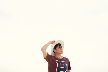 Young woman in straw hat and t-shirt with letter P. Copy Space. Air. Sea view.