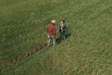 Fototapeta na wymiar Banker and farmer negotiating bank agriculture loan in barley field