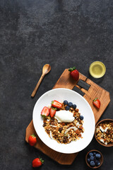 Granola with yogurt, seeds and coconut on a black background.