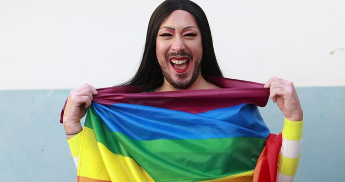 Drag queen smiling in front of camera wearing rainbow flag - Lgbt, gay, homosexual and transgender concept 