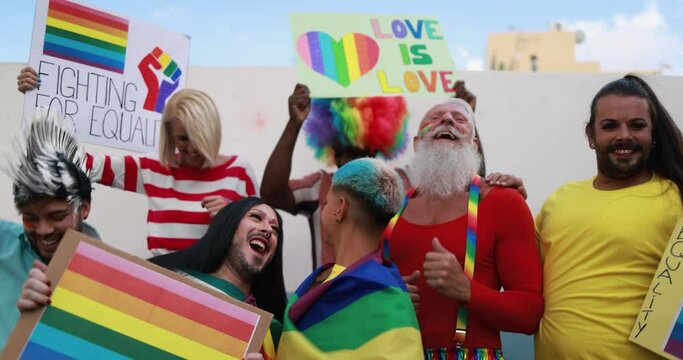 Gay people dance with banners and rainbow flags at pride party outdoor - Lgbt concept