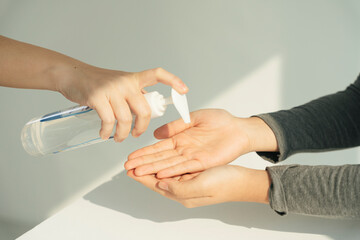 People applying using putting alcohol gel on hands.