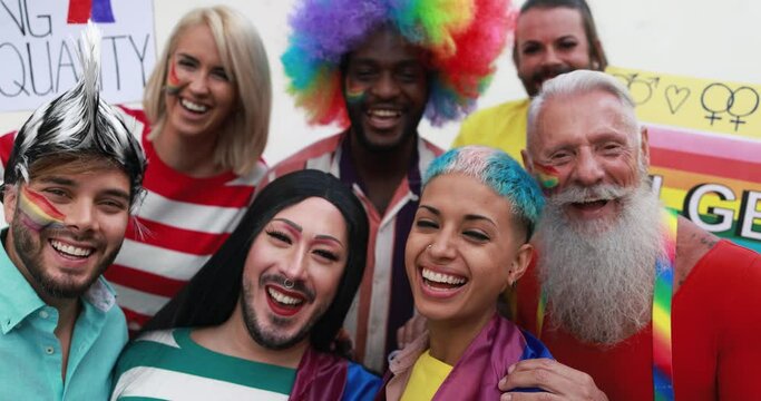 Happy gay people laughing in front of camera at lgbt pride party
