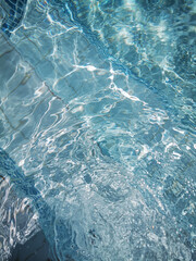 swimming pool surface very wavy and reflecting the sunlight back in a very beautiful way