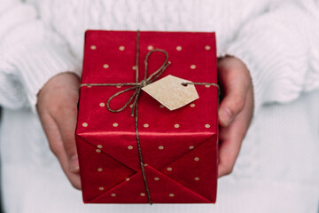New Year's gift in a red box in the hands of a girl