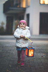 Little kid girl holding selfmade lanterns with candle for St. Martin procession. Healthy cute toddler child happy about children and family parade in kindergarten. German tradition Martinsumzug © Irina Schmidt