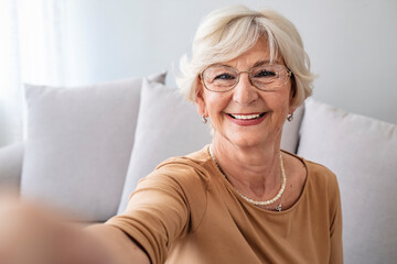 Grandma Taking Selfies at Home in the Livingroom. Close Up Portrait of Happy Cheerful Delightful Charming Beautiful Elderly Lady Granny Grandma Taking a Selfie. Old-Age, Retirement and People Concept