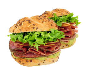 German style salami and cheese filled sandwich rolls with fresh lettuce and guacamole isolated on a white background