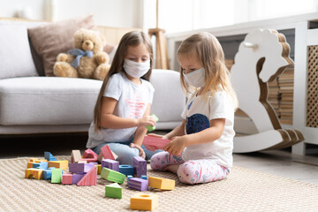 Kids children wearing mask for protect Covid-19, playing block toys in playroom. Stay at home quarantine for coronavirus pandemic prevention