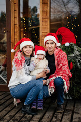 A family in Christmas hats on the doorstep.