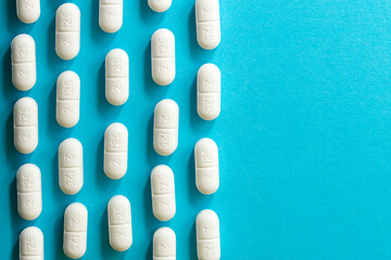 Top view of rounded white tablets on blue background