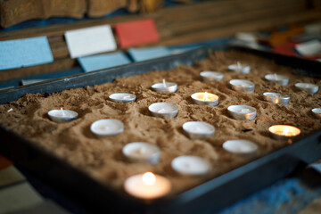 Defocused background with burning votive candles in the church. Close up