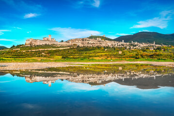 Assisi town skyline and reflection on the water. Perugia, Umbria, Italy.