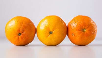 appetizing tangerines laid out in a row on white background