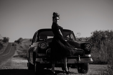 Gorgeous young Latino woman wearing classy vintage organza dress standing on the roadside at her...