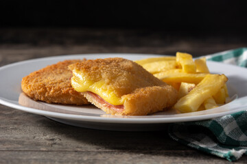 San Jacobo steak filled with cheese and ham on wooden table