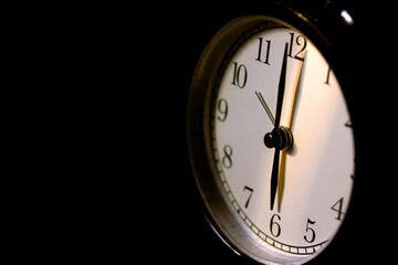 Black vintage alarm clock on black cloth black scene.