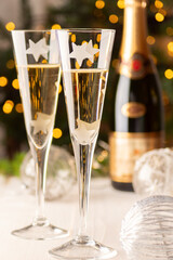 champagne glasses on the table with Christmas tree and lights