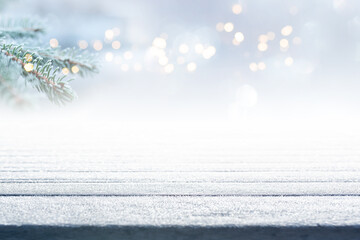 Empty frosty wooden boards with fir branch and atmospähric bokeh. Background with short depth of...