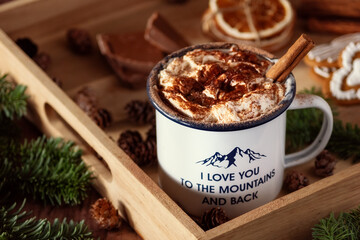 a cup of warm cacao with whipped cream and sprinkles of chocolate with Christmas decorations and gingerbread man