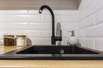 black water tap sink with faucet and soap dispenser in expensive loft kitchen