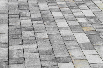 Grey pavement surface. Footpath paved with tiled stone.