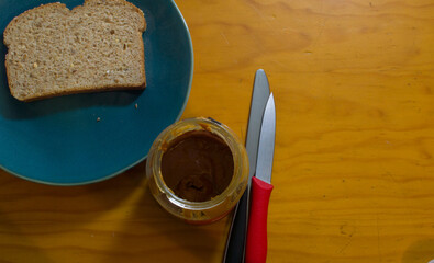 Peanut butter on toast on green plate on wooden table and hot espresso coffee