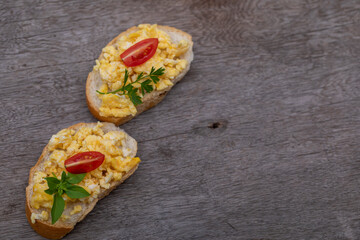 Scrambled eggs, delicious breakfast with herbs and tomatoes