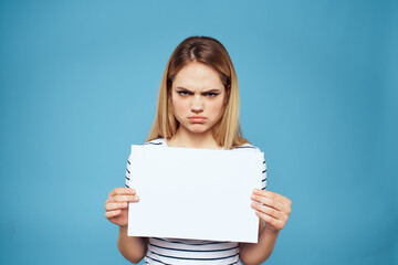 Naklejka premium Emotional woman holding a sheet of paper in her hands lifestyle close-up blue background Copy Space