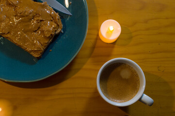 Peanut butter on toast on green plate on wooden table and hot espresso coffee