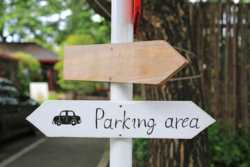 Direction parking area sign on wooden panel with arrow on the pole.