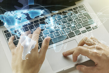 Abstract graphic digital world map with connections and hands typing on computer keyboard on...