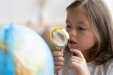 education and school concept. child girl pointing at globe