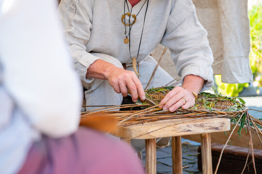 Close up of craftsman wearing rural clothes making wicker basket