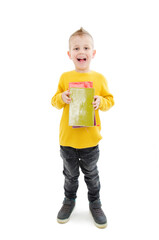 Young attractive little boy holding school books, looking excited about going back to school. Isolated on white background
