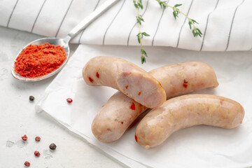 Organic spicy sausage with paprika on white paper with herbs