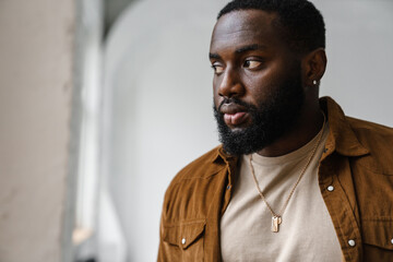 Handsome african american man posing and looking aside indoors