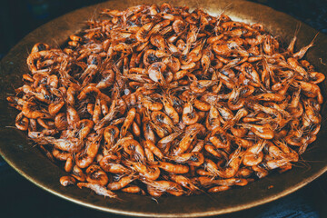 Boiled shrimp in a copper plate. Street food