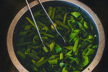 chopped green onion feathers in an aluminum bowl