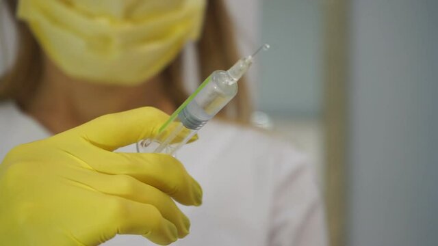 Doctor with syringe. A medical solute in the hands of the doctor.