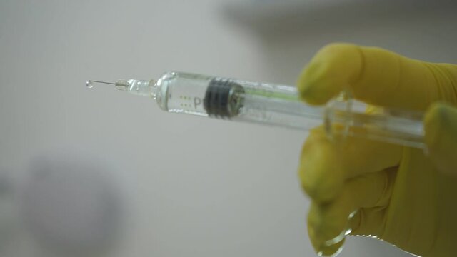 Doctor with syringe. A medical solute in the hands of the doctor.