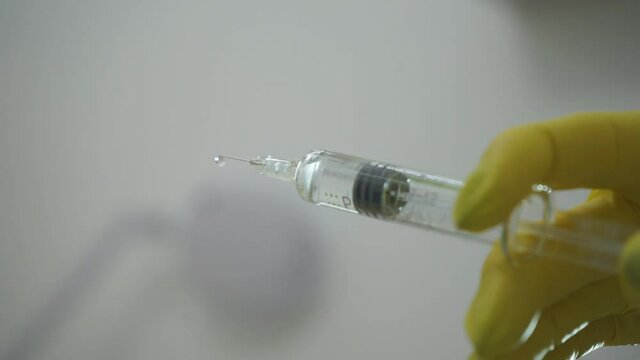Doctor with syringe. A medical solute in the hands of the doctor.