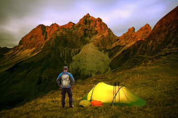 Hiker Man with Backpack and Tent enjoying Alpenglow at the mountain Grosser Wilder in Bavarian Alps, Allgau, Germany.
