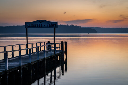 Jetty for ferry at Lake Kellersee with colorful sunset in autumn, Malente, Schleswig-Holstein