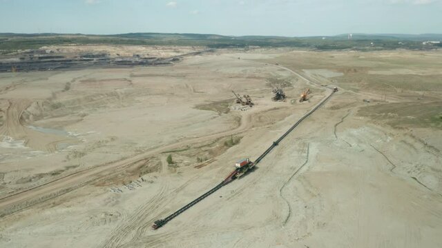 Flight over a mining quarry with equipment for coal mining. Working bucket wheel excavator. 