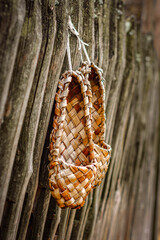 bast shoes on the fence