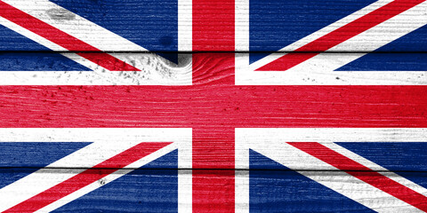 the United Kingdom flag painted on old wood plank background. Brushed natural light knotted wooden board texture. Wooden texture background flag of the United Kingdom