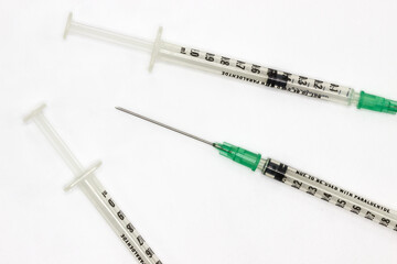 Hypodermic needles on a white background. Shringes for vaccination during the coronavirus pandemic