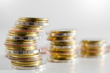 row of coin stack growing pile on white background for money saving and investment business financial and banking concept.