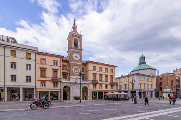 Fototapeta na wymiar The central Piazza Tre Martiri square and the clock tower in the historic center of Rimini, Emilia Romagna, Italy
